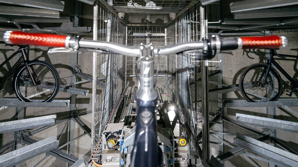 Le vélo est placé dans un rail de guidage au sein d'un système de stationnement