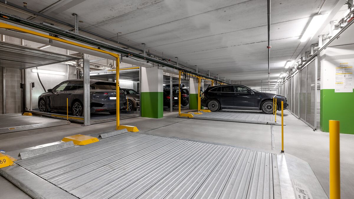 Plusieurs voitures sont stationnées sur la plateforme de stationnement dans un parking souterrain.