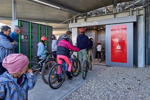 Des enfants à vélo se trouvent devant l'entrée du système de stationnement automatique pour vélos