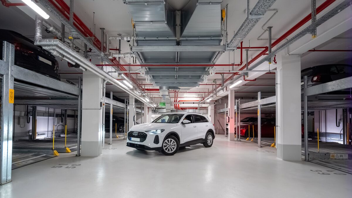 La voiture est garée dans l'allée du parking souterrain, entre deux systèmes Combilift