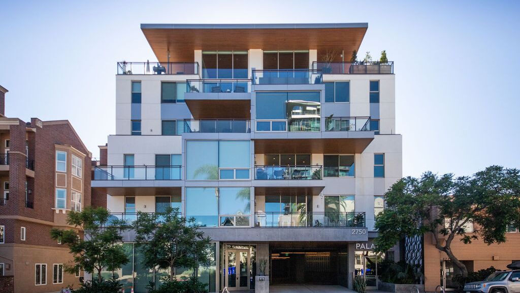 Immeuble résidentiel moderne avec accès intégré au système de stationnement, balcons spacieux et architecture de haute qualité.