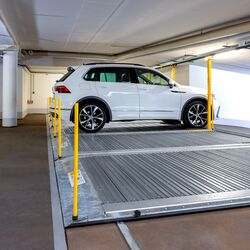 Plate-forme de stationnement avec une voiture garée dessus dans un parking souterrain