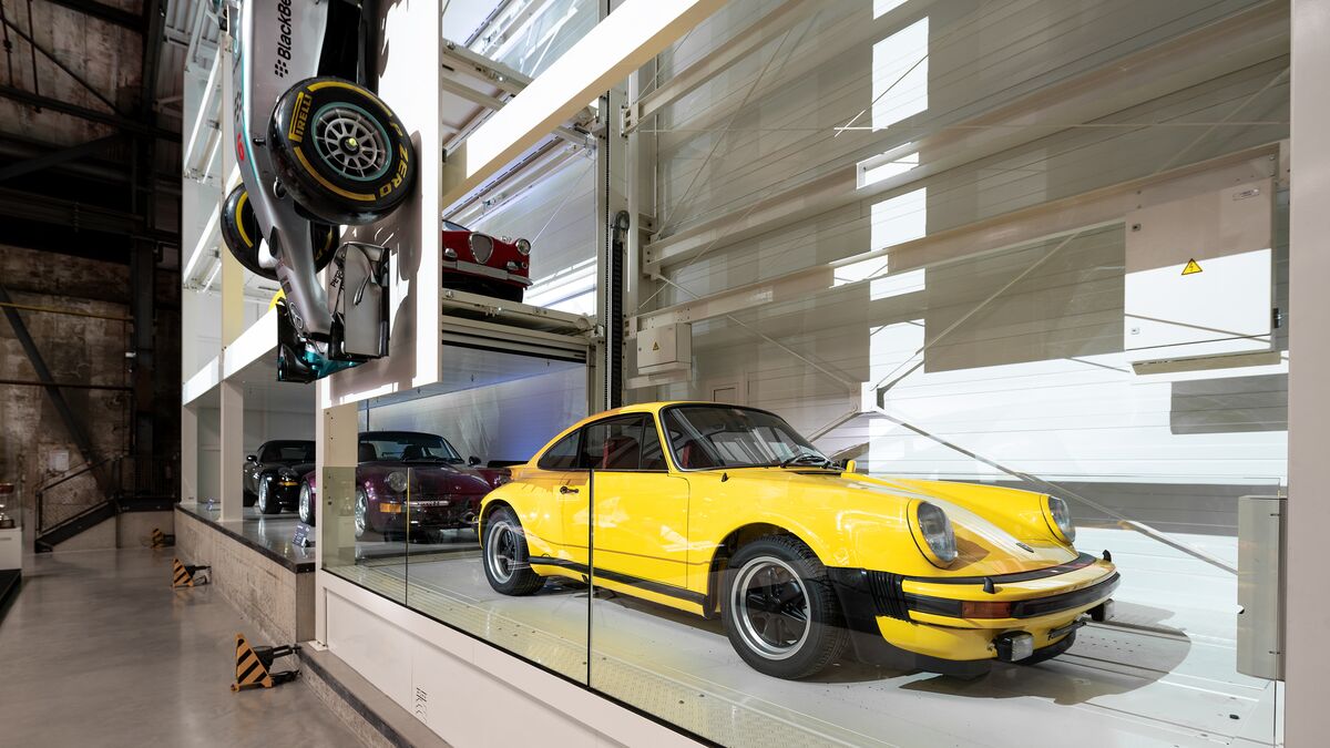 Une voiture de collection jaune garée dans un système de stationnement au sein d'un musée