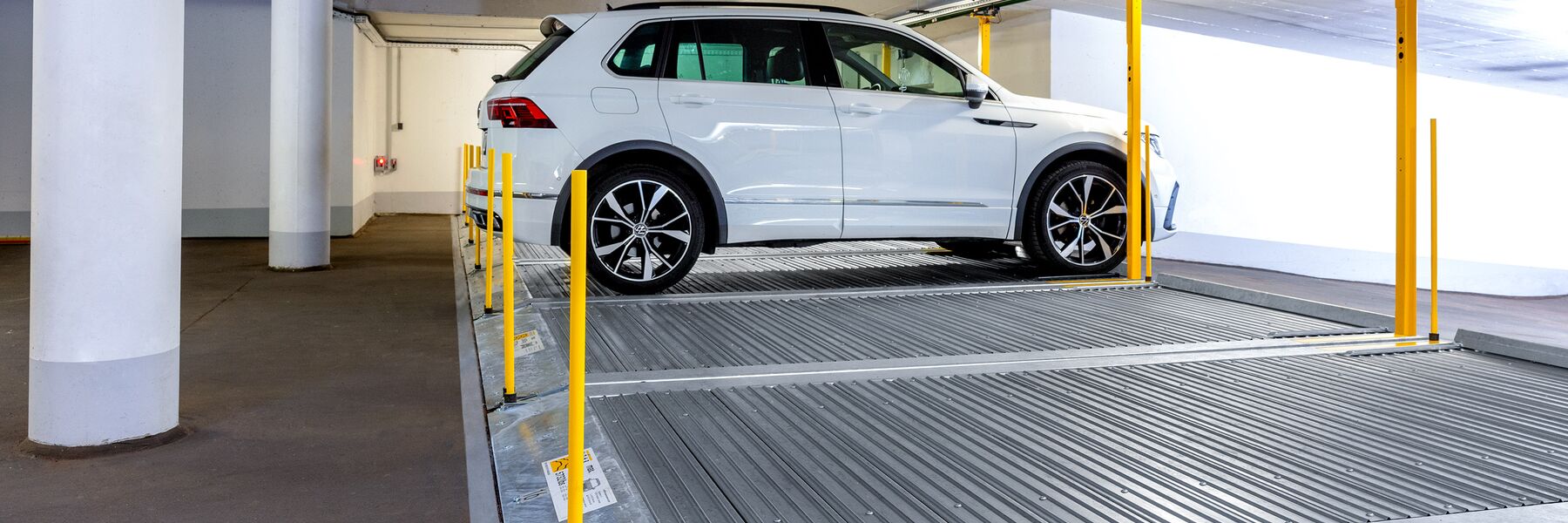 Plate-forme de stationnement avec une voiture garée dessus dans un parking souterrain
