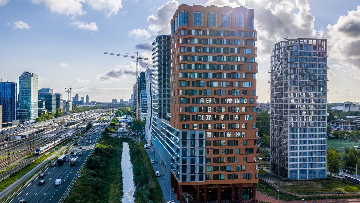 Quartier urbain moderne avec des immeubles de grande hauteur, des espaces verts et de bonnes infrastructures.