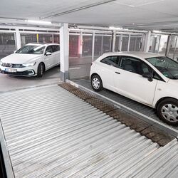 Een persoon rijdt een parkeersysteem binnen