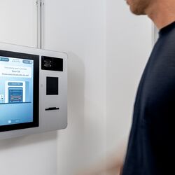Une personne utilise le terminal de commande du WÖHR Combilift 542/543 pour gérer le processus de stationnement.
