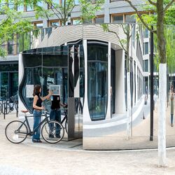 Une femme à vélo utilise un écran sur le système de stationnement pour vélos