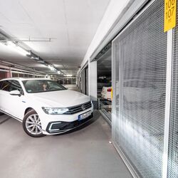 Een persoon rijdt een parkeersysteem binnen